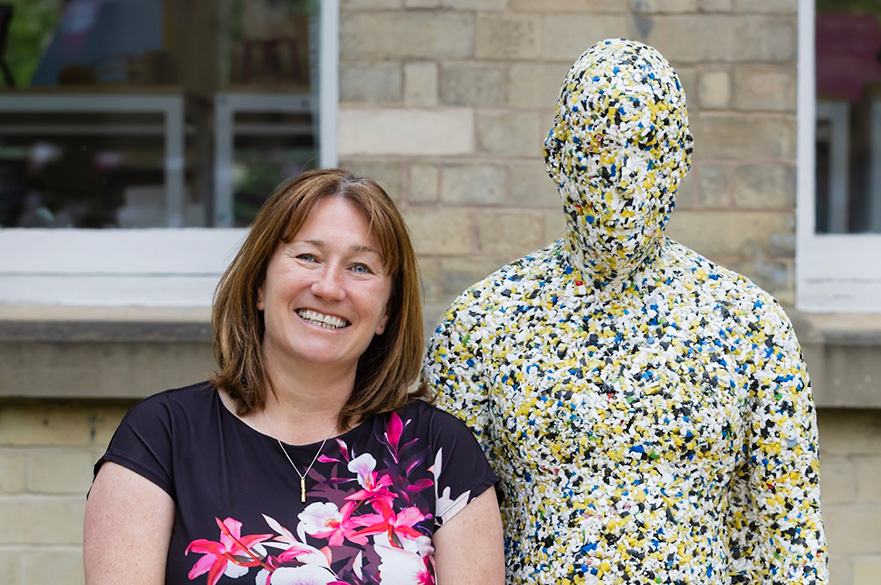 Anne smiling in front of a sculpture at Newton