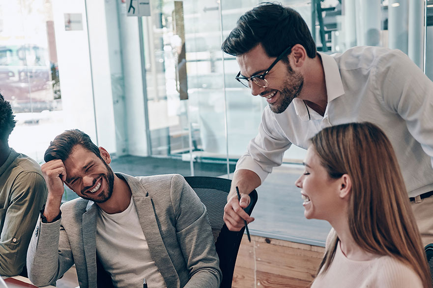 Group of adults smiling around a table in an office